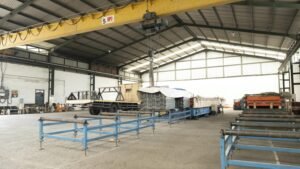 Suasana pabrik bondek dan spandek PT MMMA dengan overhead crane sedang memindahkan material baja ringan